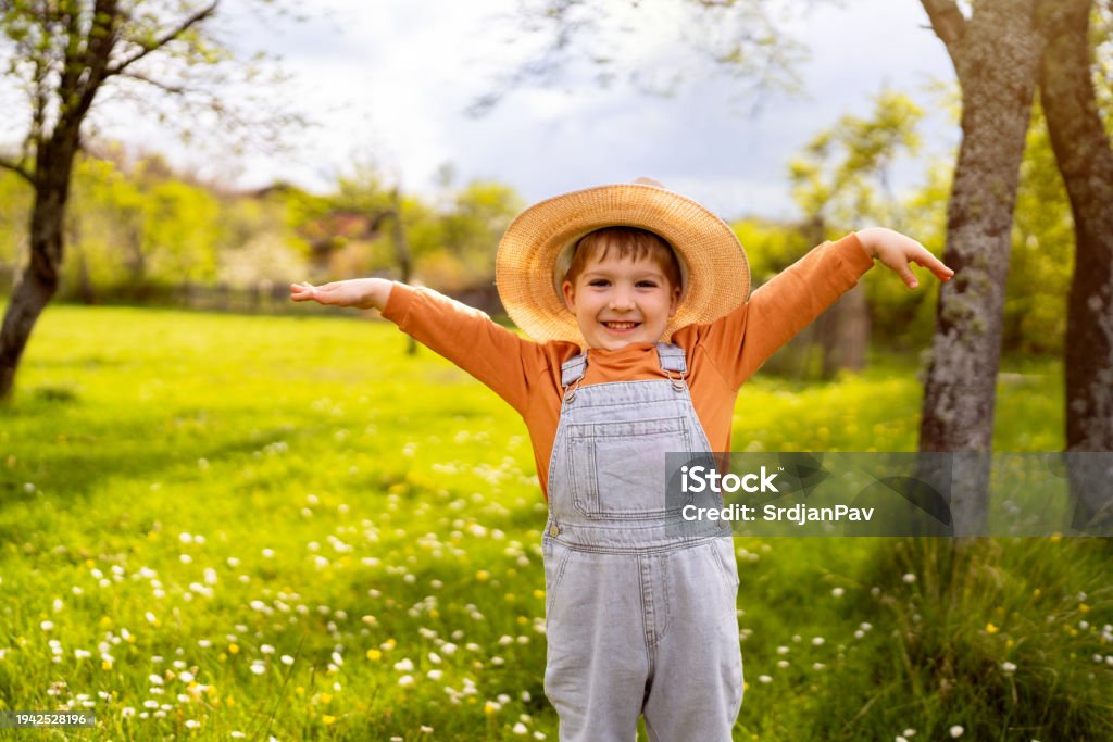 Portrait of cute little boy with sun hat on enjoying a carefree spring day in nature.