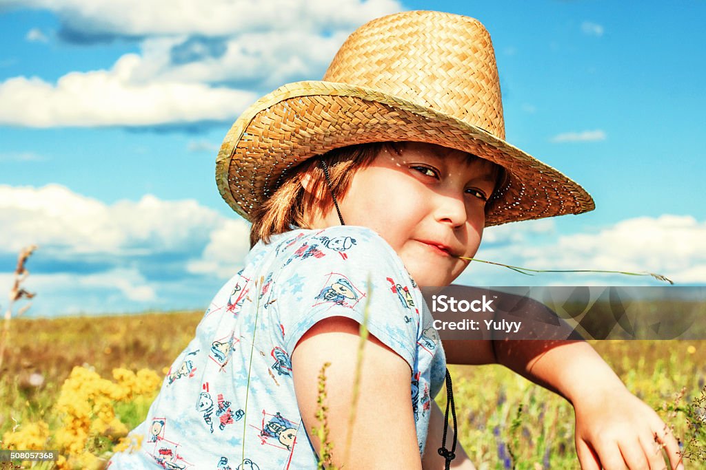 The picture on the nature of the child pasiruoses in a cowboy hat. Shooting in the summer, near the lake