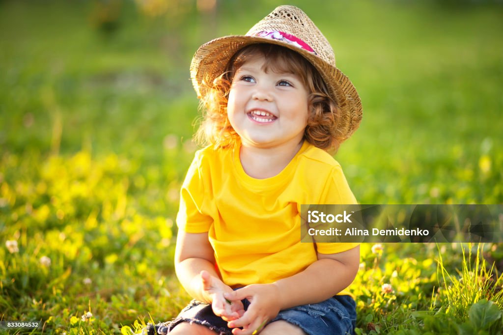 Funny little kid wearinf straw hat, summer sunny day, lifestyle, happy child outdoors, family farm, toddler farmer